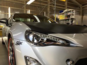 6・86プレミアムコーティング＆ボンネットラッピング（運転席側ヘッドライト施工後）
